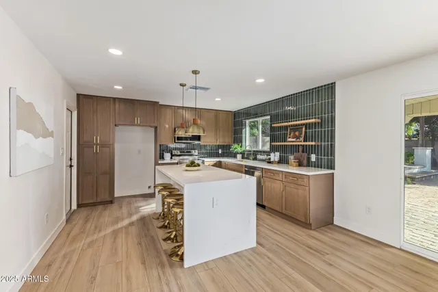a kitchen with kitchen island white cabinets stainless steel appliances and wooden floor