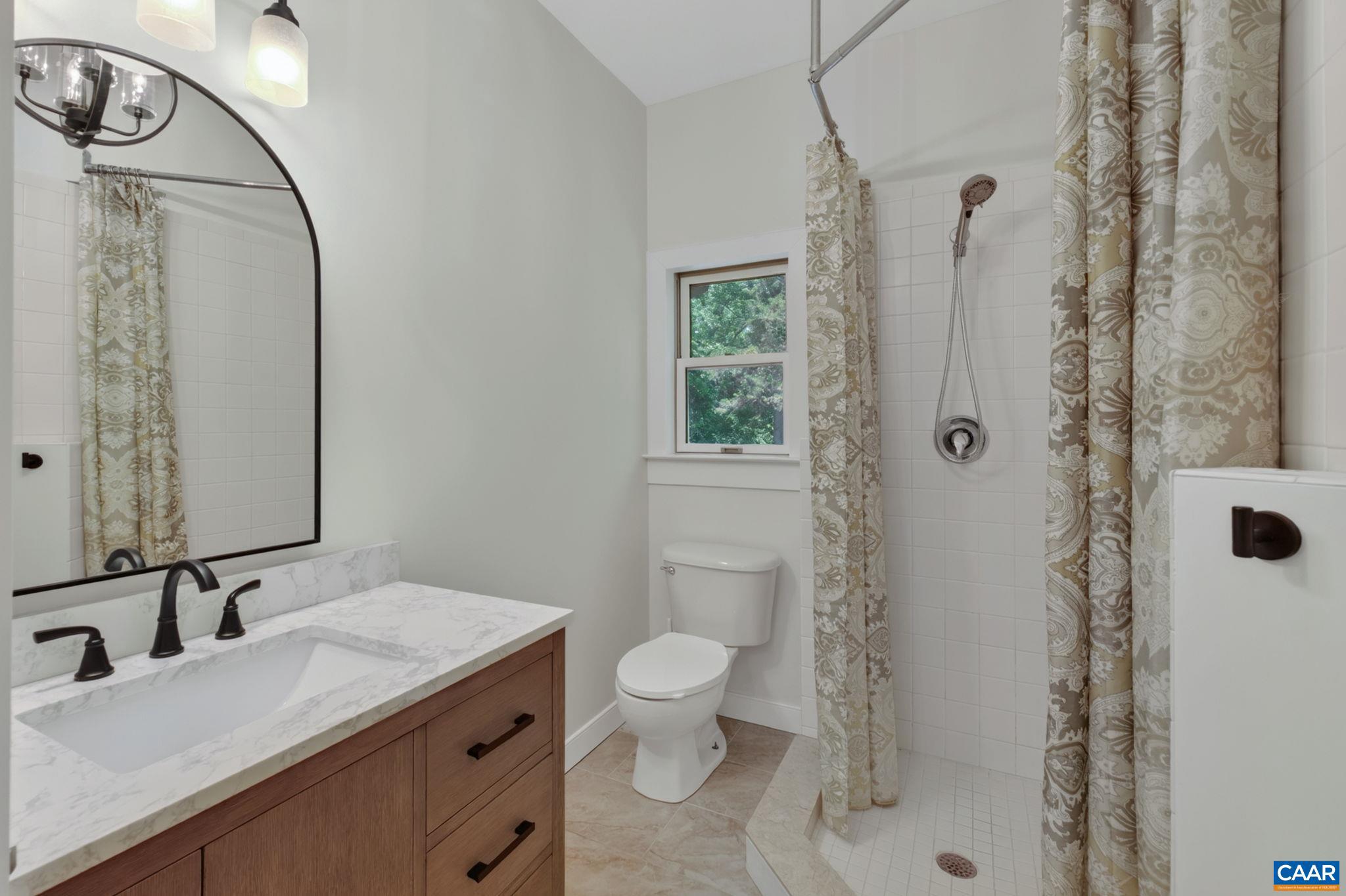 6285 Jarmans Gap Road Crozet, VA 22932 - Photo 13 of 65 a bathroom with a granite countertop sink a toilet and shower