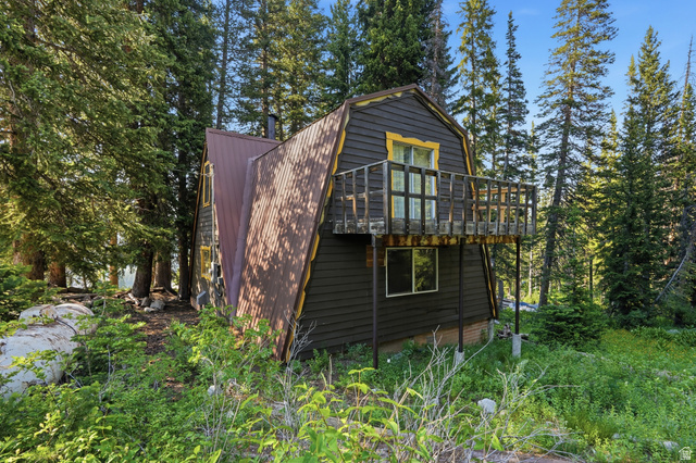 8505 South Snake Crk Road Salt Lake City, UT 84121 - Photo 2 of 67 A-frame structure featuring a dark siding and a brown corrugated metal roof