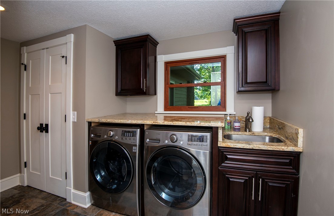 17015 Ravenna Road Chagrin Falls, OH 44023 - Photo 26 of 34 Gorgeous first floor laundry with new floors, Paint granite, utility tub and cabinetry. stainless washer and dryer less then 5 years old. Full bath off the laundry to the right.
