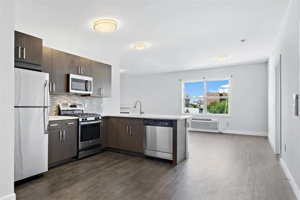a kitchen with stainless steel appliances granite countertop a stove a sink dishwasher a refrigerator and a oven with white countertops