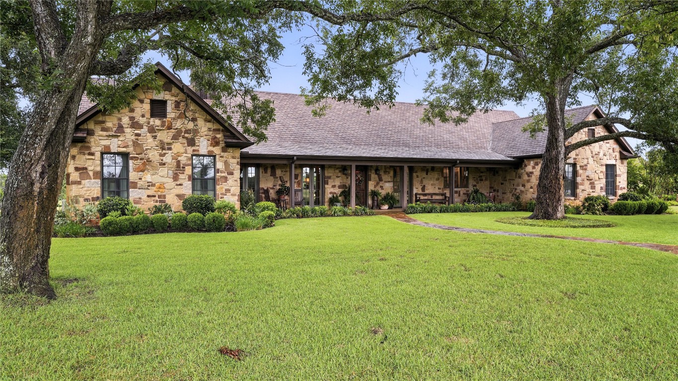 705 Antioch Road Paige, TX 78659 - Photo 2 of 40 a front view of a house with a garden