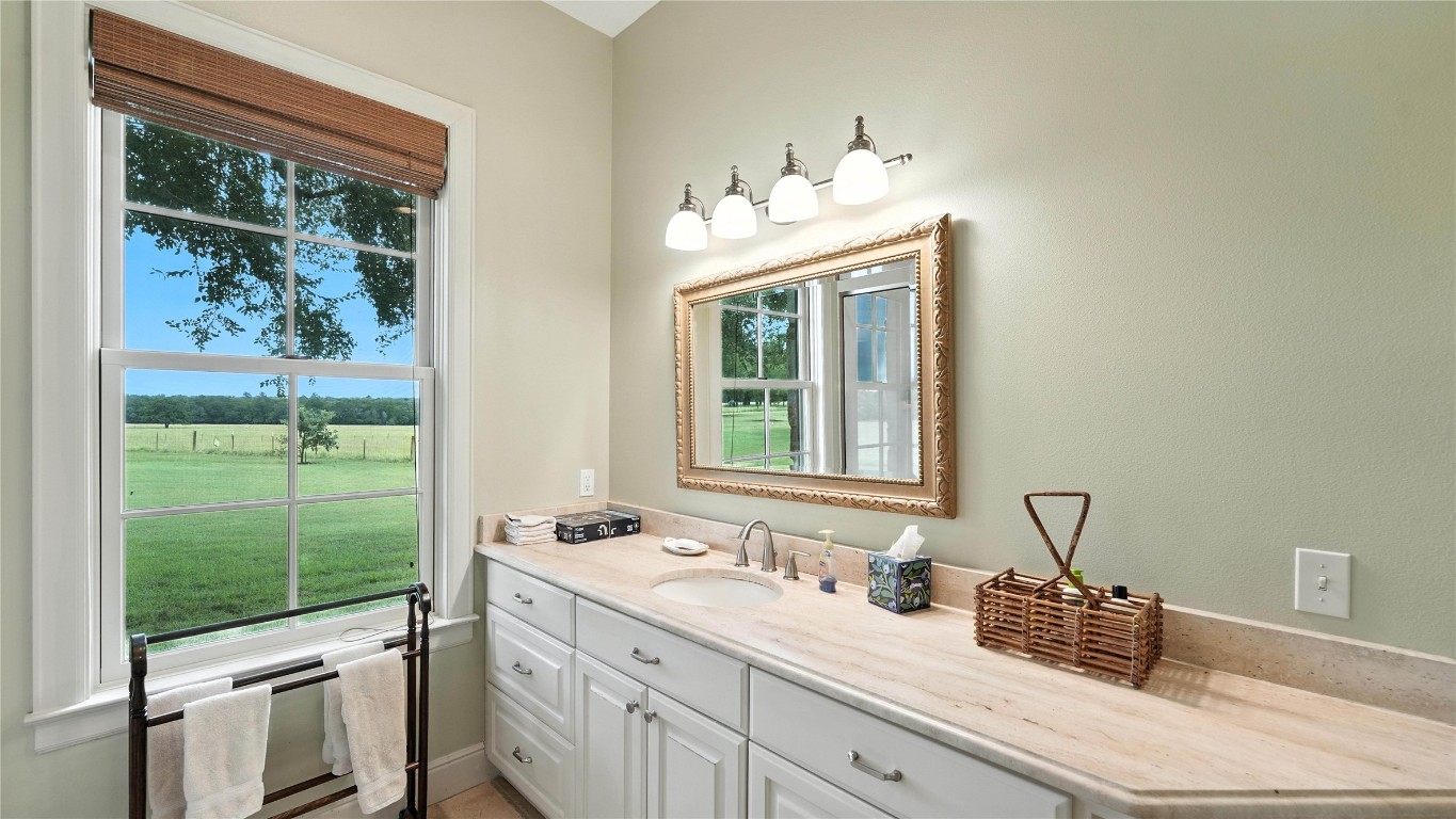 705 Antioch Road Paige, TX 78659 - Photo 25 of 40 a bathroom with a double vanity sink and a window