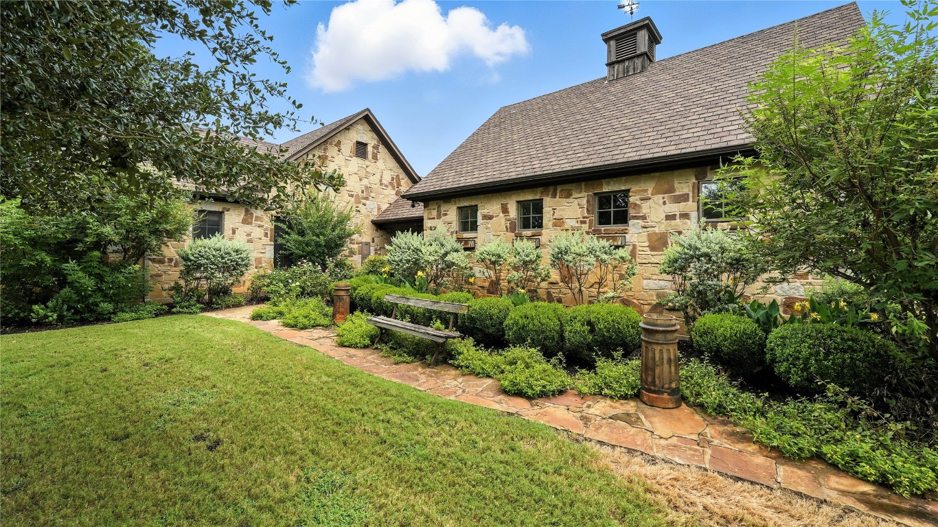 705 Antioch Road Paige, TX 78659 - Photo 3 of 40 a view of a house with garden and pathway