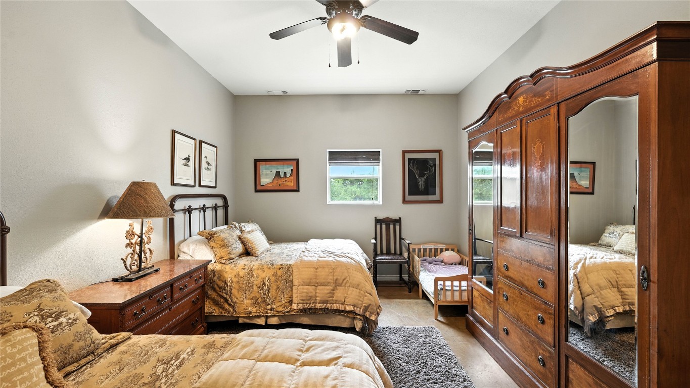 705 Antioch Road Paige, TX 78659 - Photo 32 of 40 a bedroom with bed and a chandelier