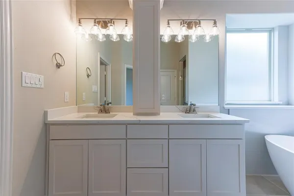 a bathroom with double sink and a mirror
