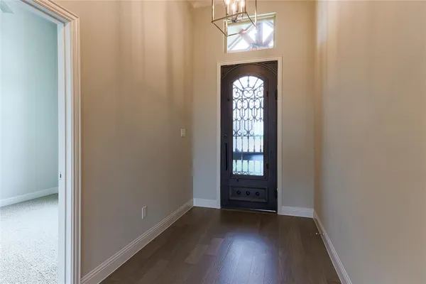 an empty room with windows wooden floor and hallway