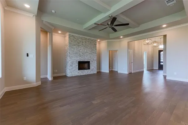 a view of an empty room with wooden floor a fireplace