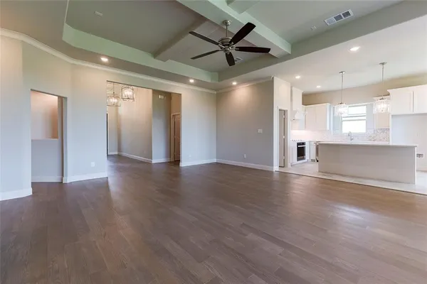 a view of a livingroom with a ceiling fan wooden floor and a ceiling fan
