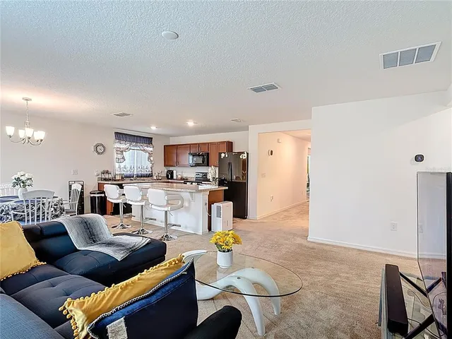 a living room with furniture and kitchen view