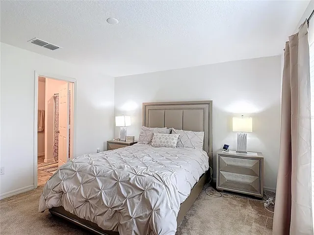 a bedroom with a bed and a lamp