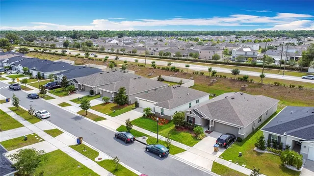 an aerial view of residential houses with outdoor space and ocean view