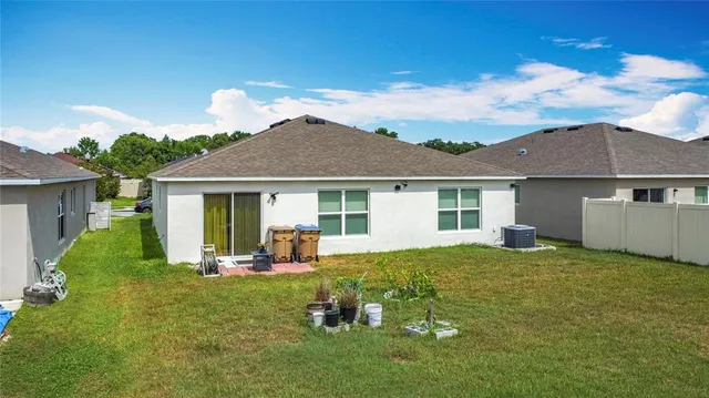 a backyard of a house with table and chairs