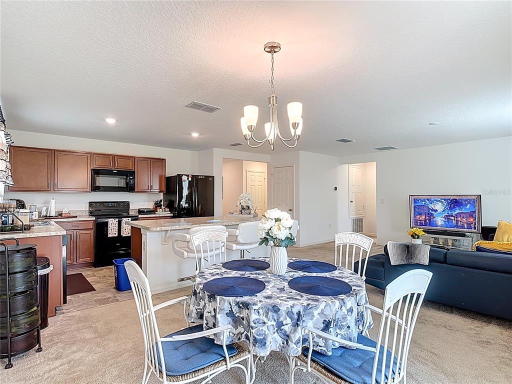 3216 Casa Del Rey Avenue Kissimmee, FL 34746 - Photo 9 of 32 a view of a dining room and livingroom with furniture wooden floor a chandelier