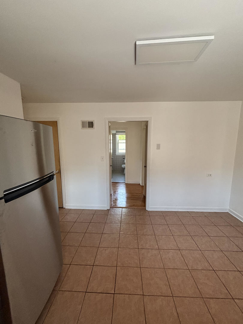 5658 North Richmond Street, Unit 2 Chicago, IL 60659 - Photo 7 of 12 a view of a refrigerator in kitchen and an empty room