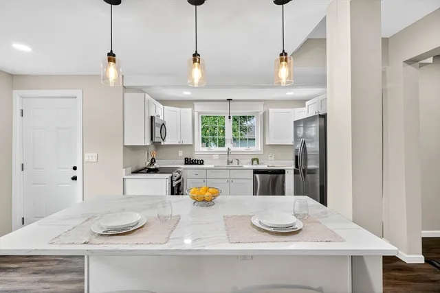a kitchen with a sink a refrigerator and window