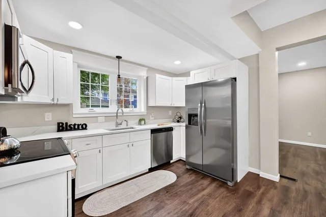 a kitchen with stainless steel appliances a stove microwave and sink