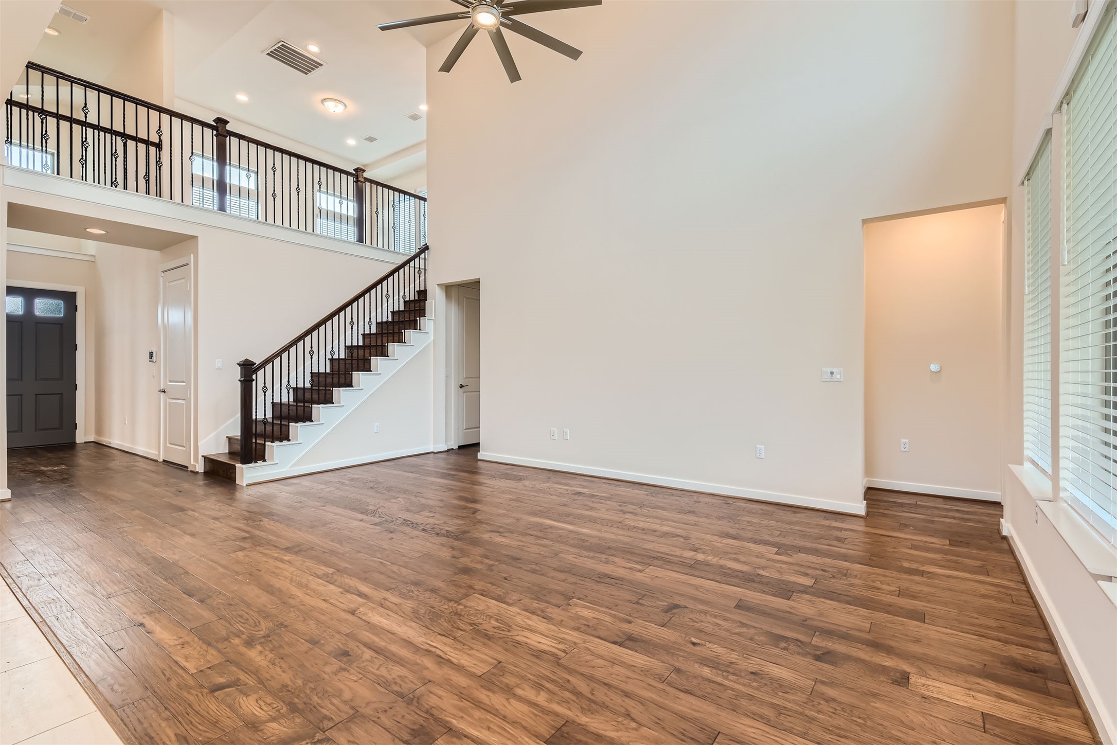 8313 Spire View Austin, TX 78744 - Photo 7 of 33 A spacious living area with soaring ceilings and rich hardwood flooring provides an inviting atmosphere.