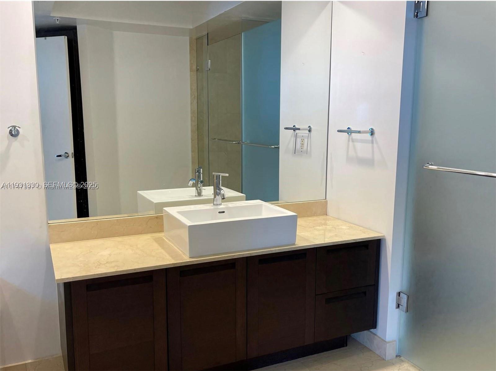 250 Sunny Isles Boulevard, Unit 31003 Sunny Isles Beach, FL 33160 - Photo 15 of 25 a bathroom with a sink and a mirror