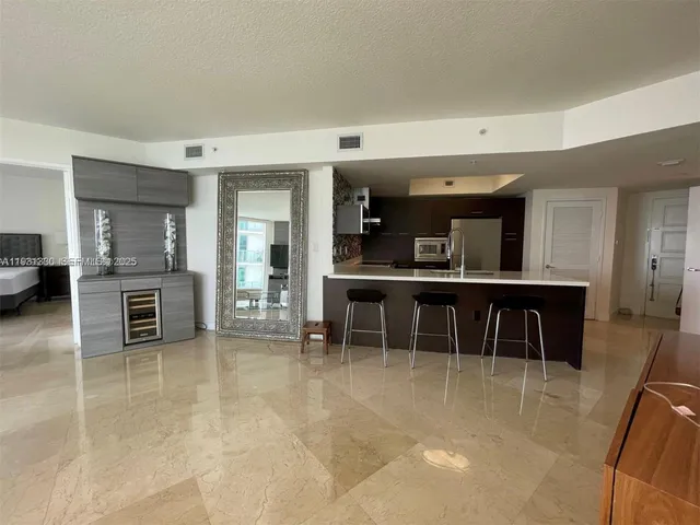 a view of a kitchen with kitchen island granite countertop counter top space and stainless steel appliances