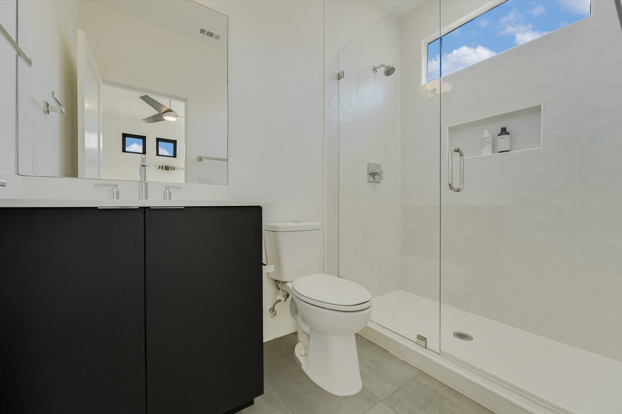 907 Redd Street, Unit 2 Austin, TX 78745 - Photo 12 of 20 Attached bath to bedroom one- floor to ceiling tile in the shower and quartz countertops.