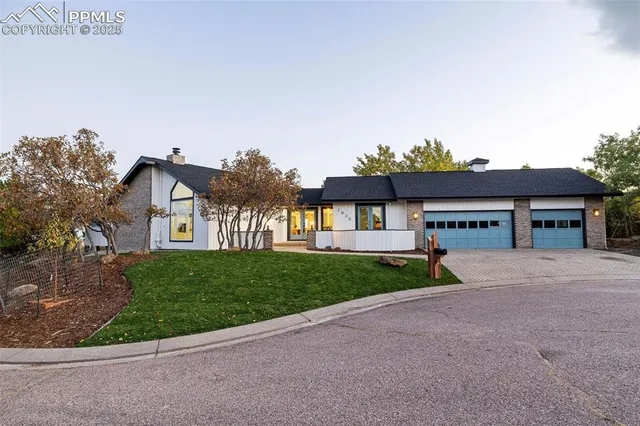 a view of house with a yard and potted plants
