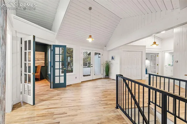 a view of a hallway with wooden floor and windows