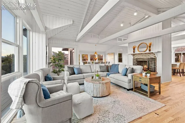 a living room with fireplace furniture and a large window