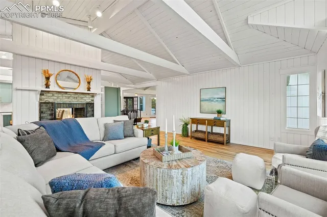 a living room with furniture fireplace and a large window