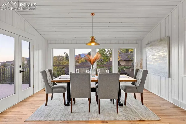 a dining room with furniture a chandelier and wooden floor