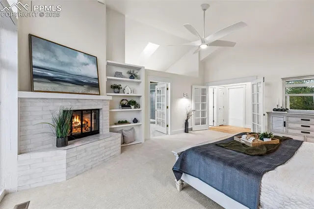 a bedroom with a bed a fireplace and a flat screen tv