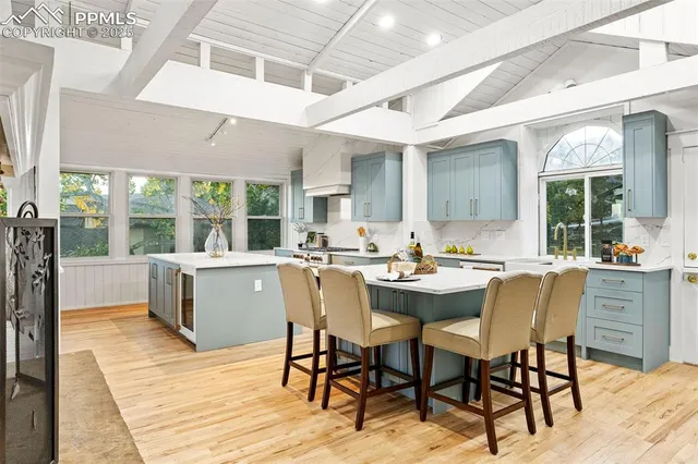 a dining hall with stainless steel appliances kitchen island a table and chairs in it