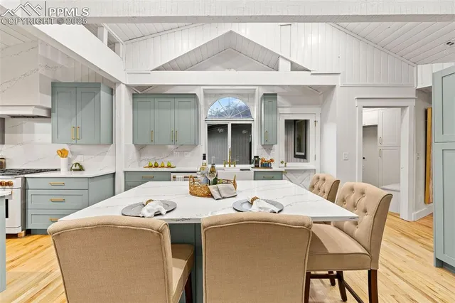 a kitchen with a dining table chairs and white cabinets