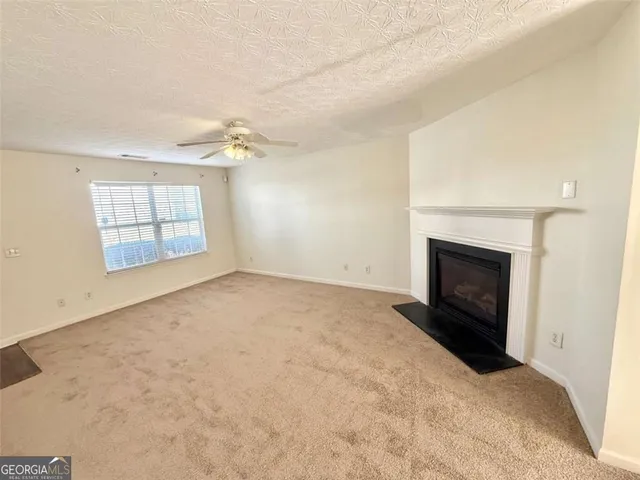 an empty room with windows and fireplace