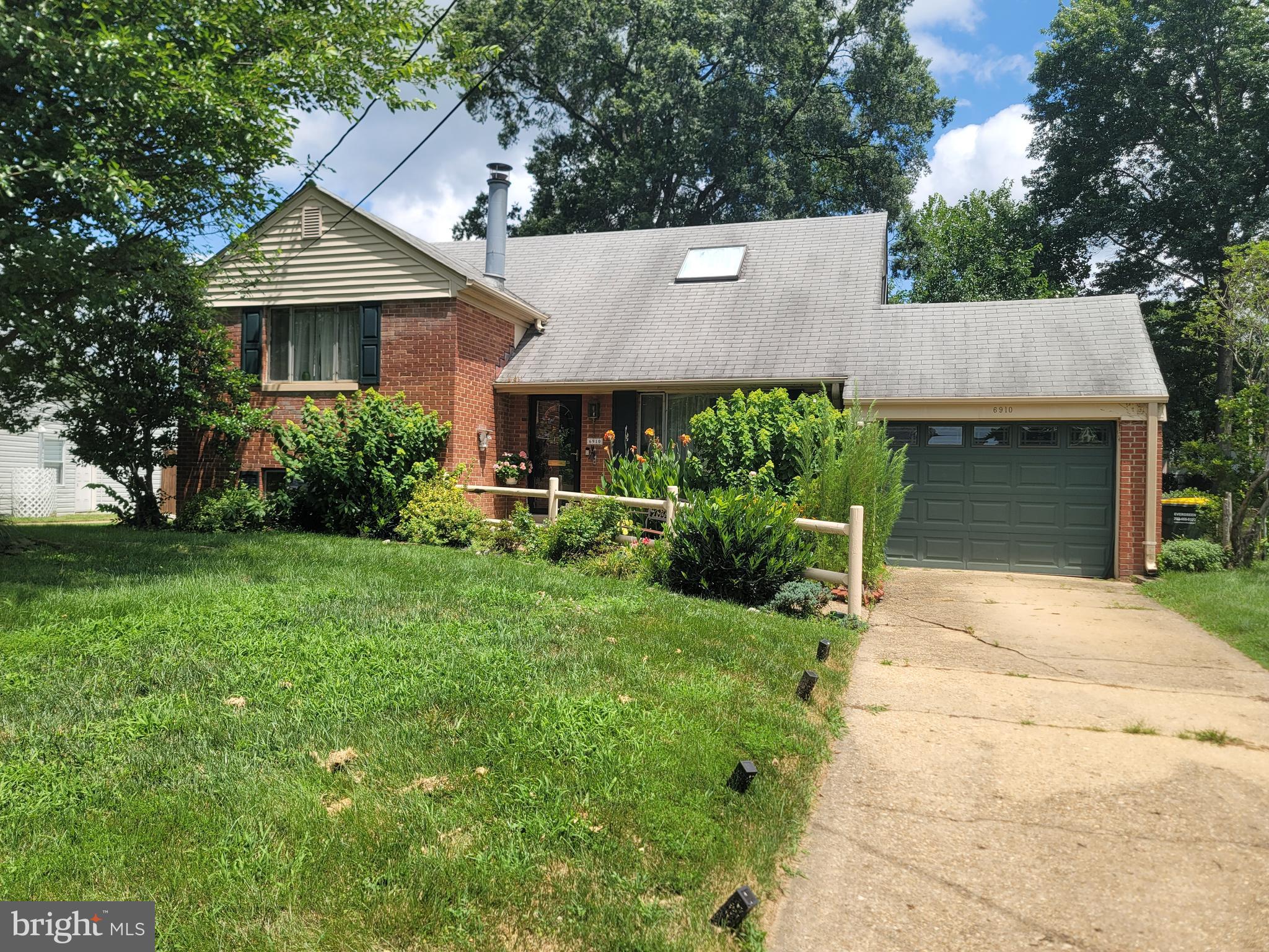 6910 Gilbert Street Springfield, VA 22150 - Photo 1 of 29 a front view of a house with a yard and garage