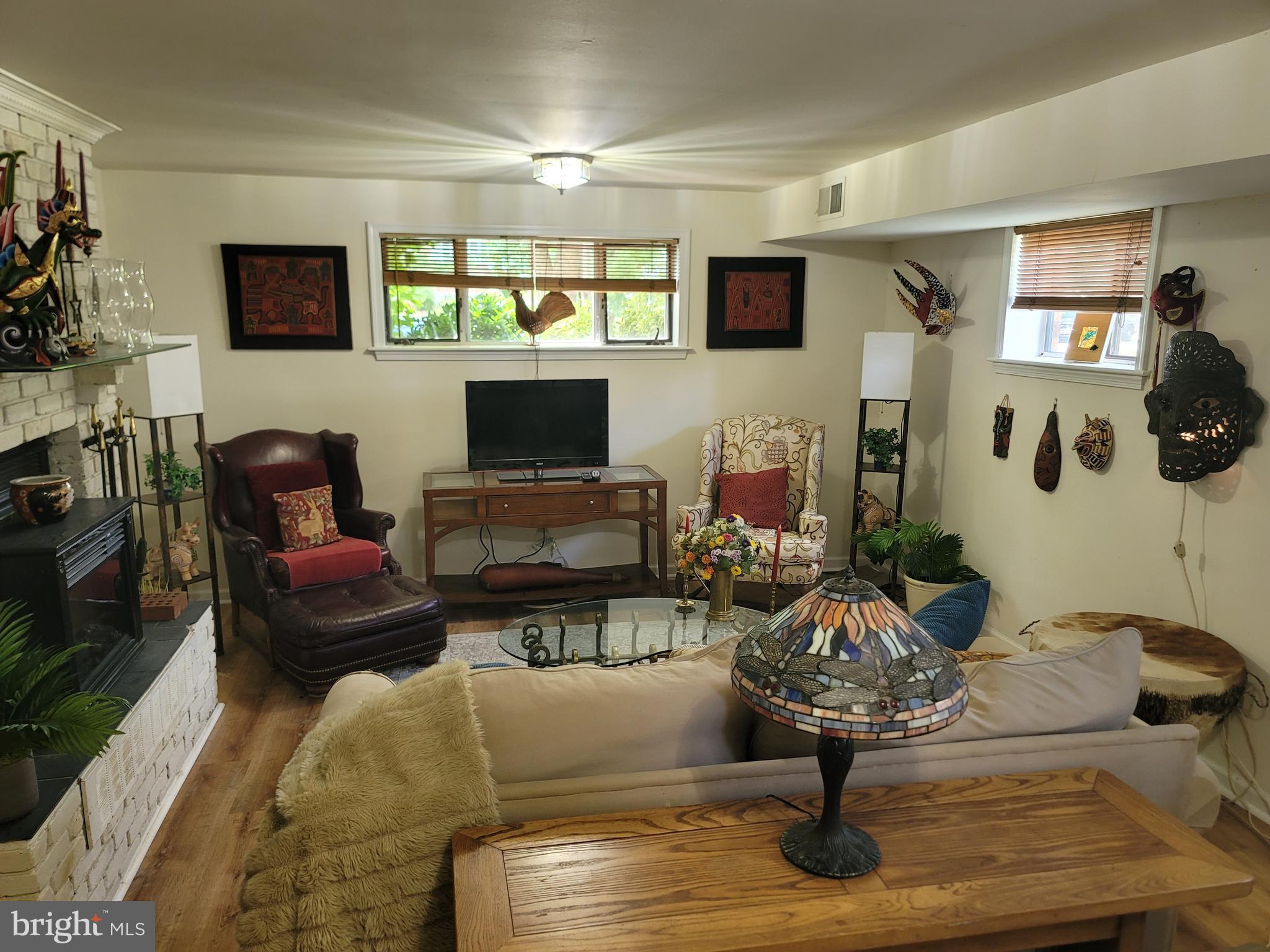 6910 Gilbert Street Springfield, VA 22150 - Photo 18 of 29 a living room with furniture a fireplace and a flat screen tv