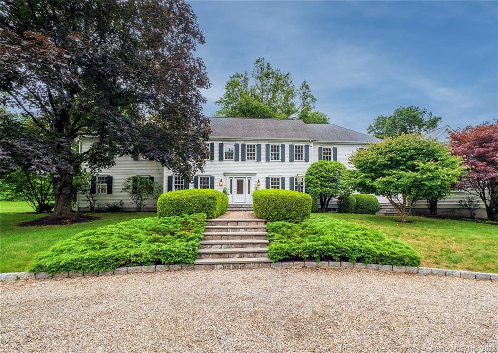 97 Warncke Road Wilton, CT 06897 - Photo 1 of 1 a front view of a house with a yard and potted plants