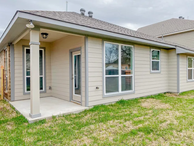 a view of a house with a small yard and wooden floor and fence