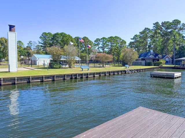 a view of swimming pool with seating space and trees in the background