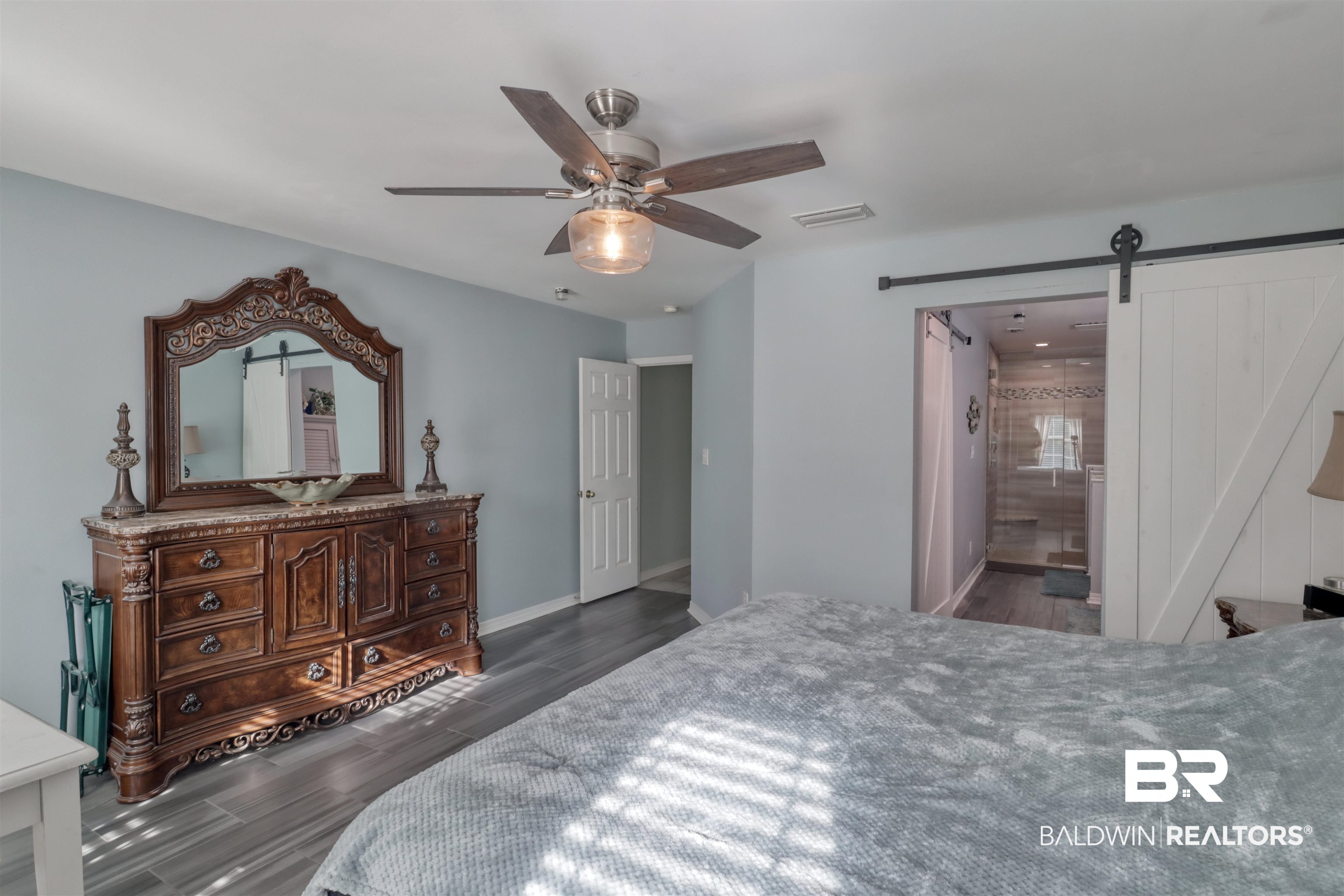 12893 Hunters Chase Foley, AL 36535 - Photo 25 of 42 Bedroom with visible vents, baseboards, ceiling fan, wood finished floors, and a barn door