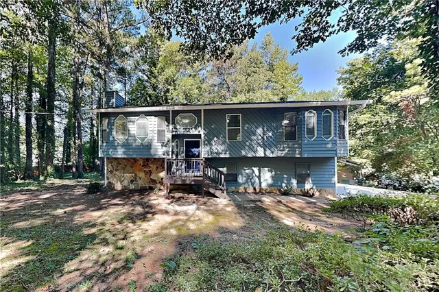 a view of house with car parked next to a road