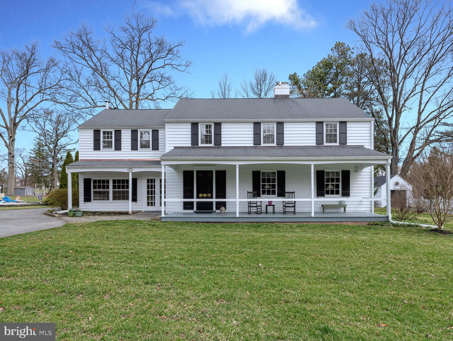 a front view of a house with a garden and trees