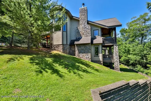 a view of a house with a yard potted plants and large tree