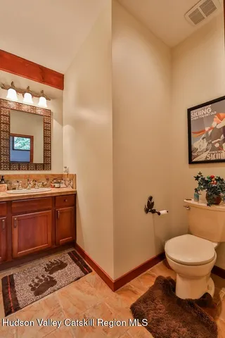 a bathroom with a toilet a sink and mirror