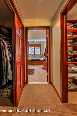 a view of a hallway with wooden floor and windows