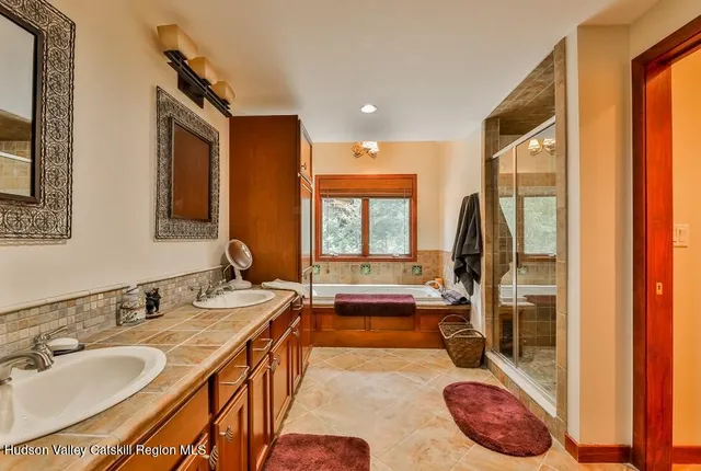 a spacious bathroom with a tub and 2 sink
