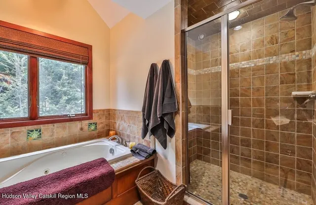 a bathroom with a bathtub and next to a window