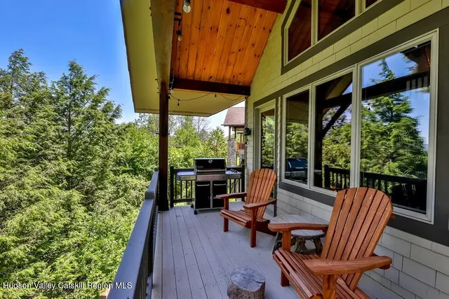 a view of a patio with table and chairs potted plants with wooden floor and fence