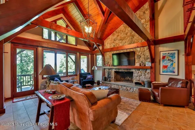a living room with furniture a fireplace and a floor to ceiling window