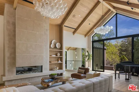 a living room with furniture a fireplace and a floor to ceiling window